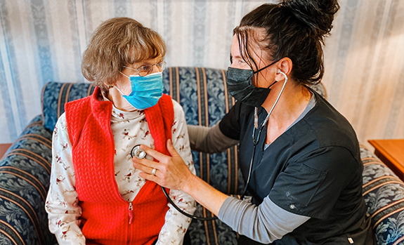 a nurse taking a woman's heartbeat