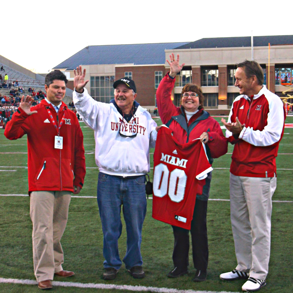 four sports fans on a football field